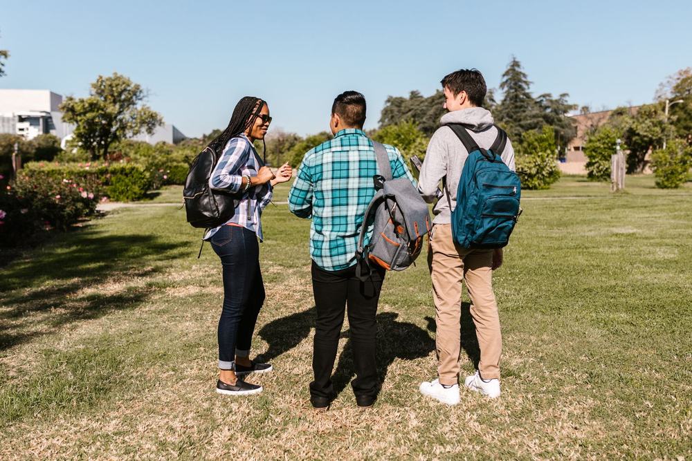 A diverse group of college students walking together with backpacks
