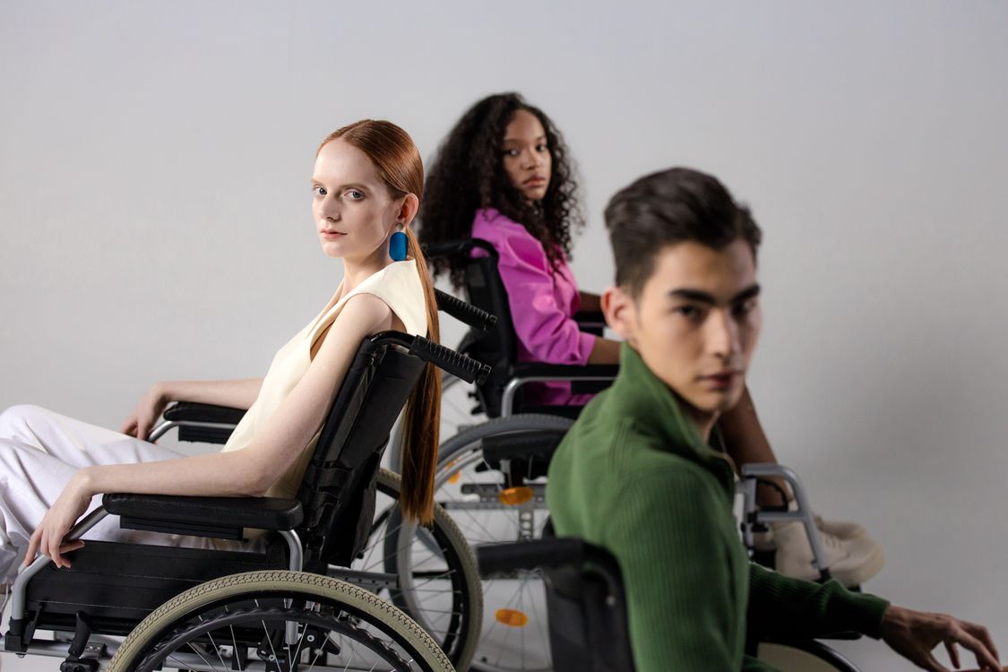A racially diverse group of adults who use wheelchairs gathered together